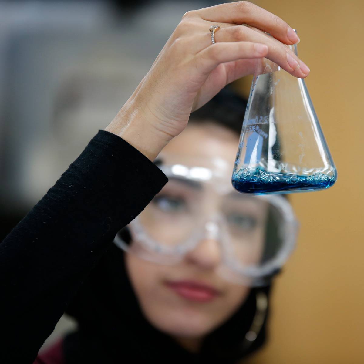 girl holding a beaker in science class